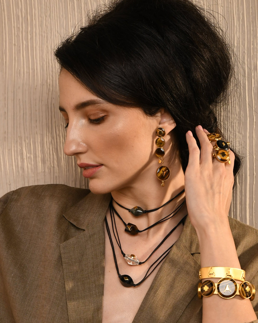 Woman wearing earrings and a necklace with a brown background