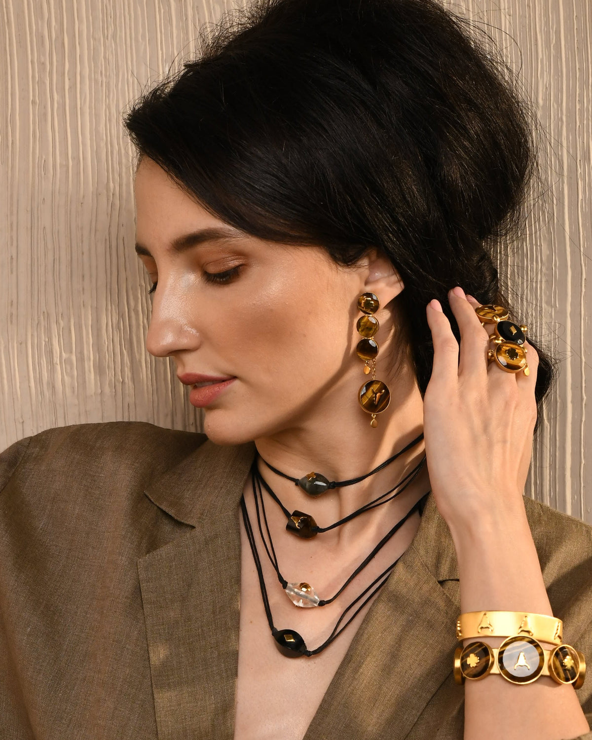 Woman wearing earrings and a necklace with a brown background
