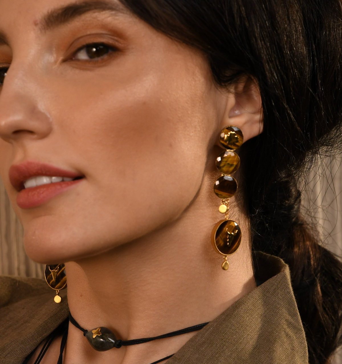 Woman wearing earrings and a necklace with a brown background