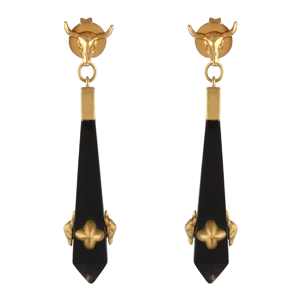 Pair of gold and black earrings on a white background