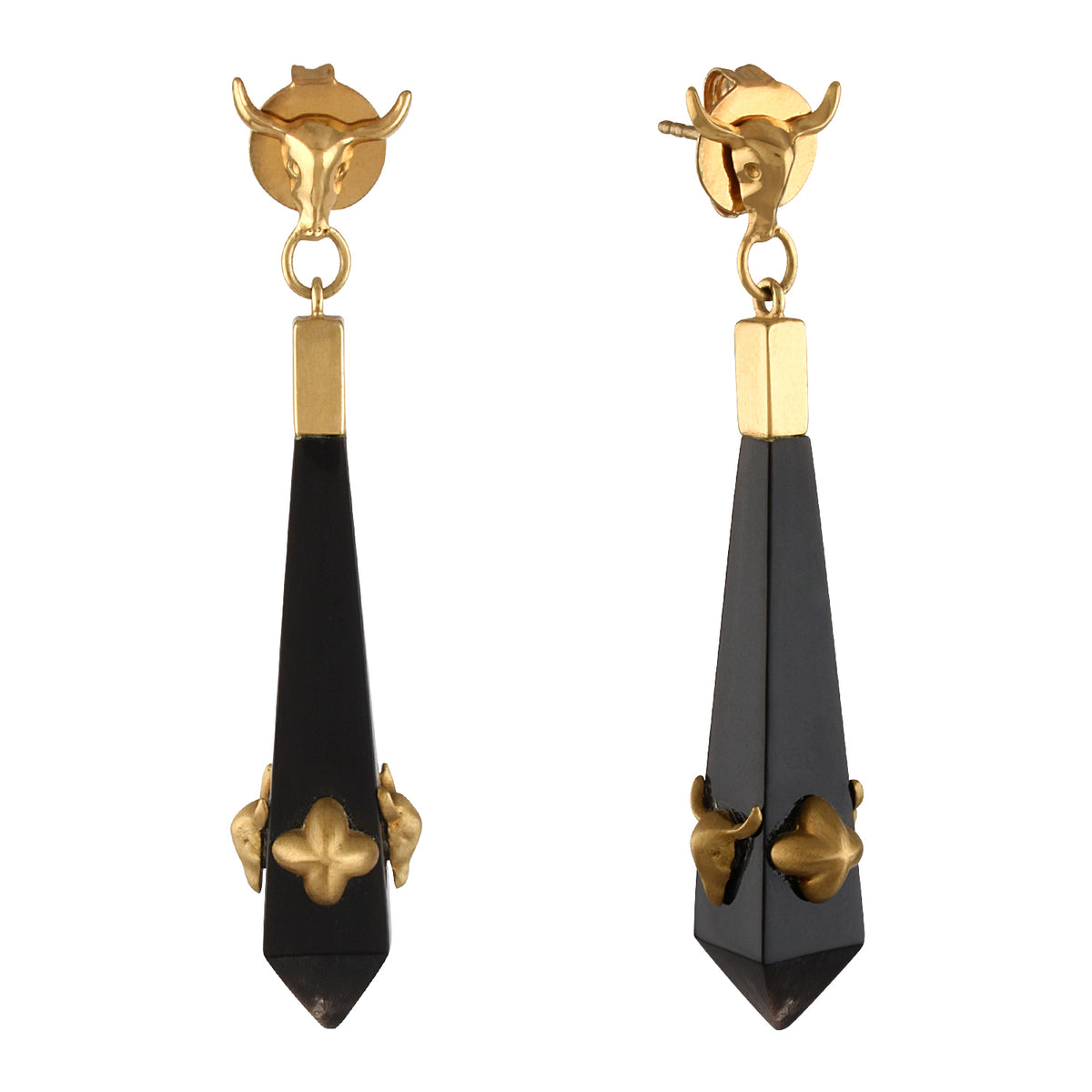 Pair of earrings with gold tops and black droplets on a white background