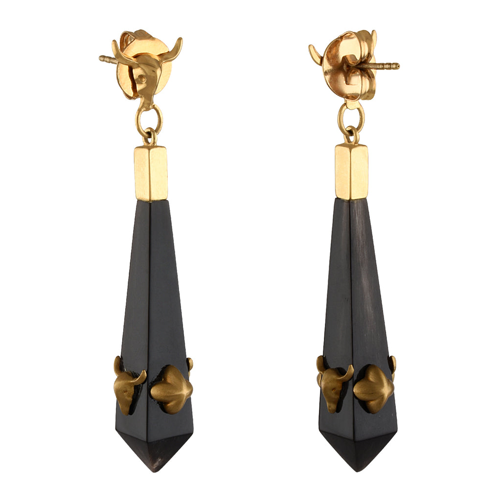 Pair of gold and black earrings on a white background