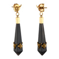 Pair of gold and black earrings on a white background