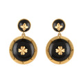 Pair of gold and black earrings on a white background