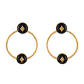 Pair of gold hoop earrings with black circular centers and gold accents on a white background