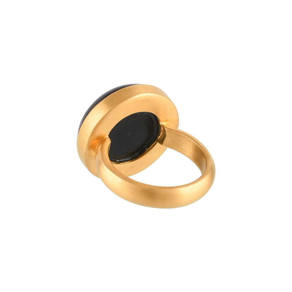 Gold ring with a black circular buffalo horn material and gold floral design on a white background