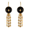 Gold and black earrings with buffalo horn beads on a white background