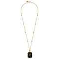 A gold necklace featuring a delicate chain with small star-like beads and a rectangular pendant with a bull symbol, displayed against a solid black background.