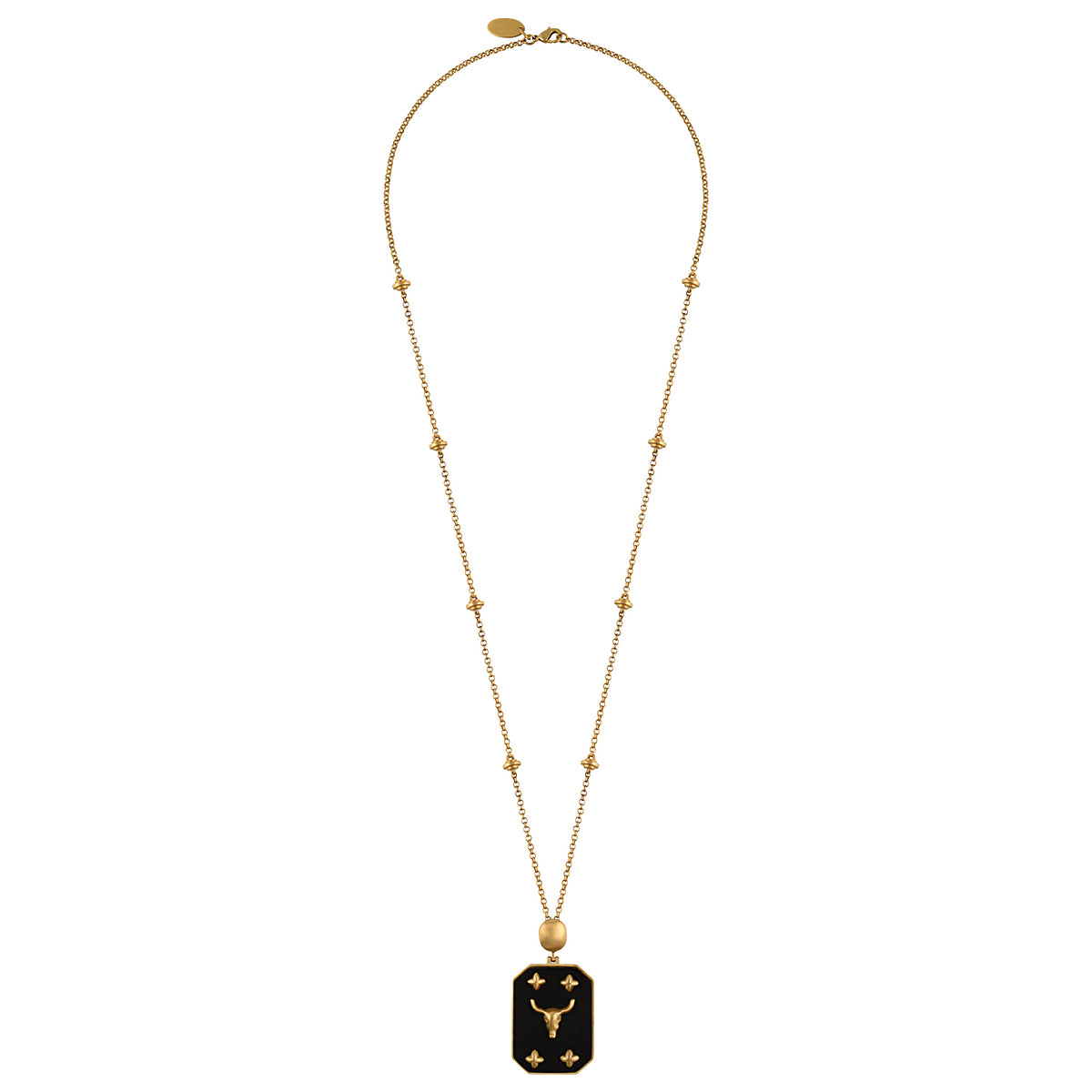 A gold necklace featuring a delicate chain with small star-like beads and a rectangular pendant with a bull symbol, displayed against a solid black background.